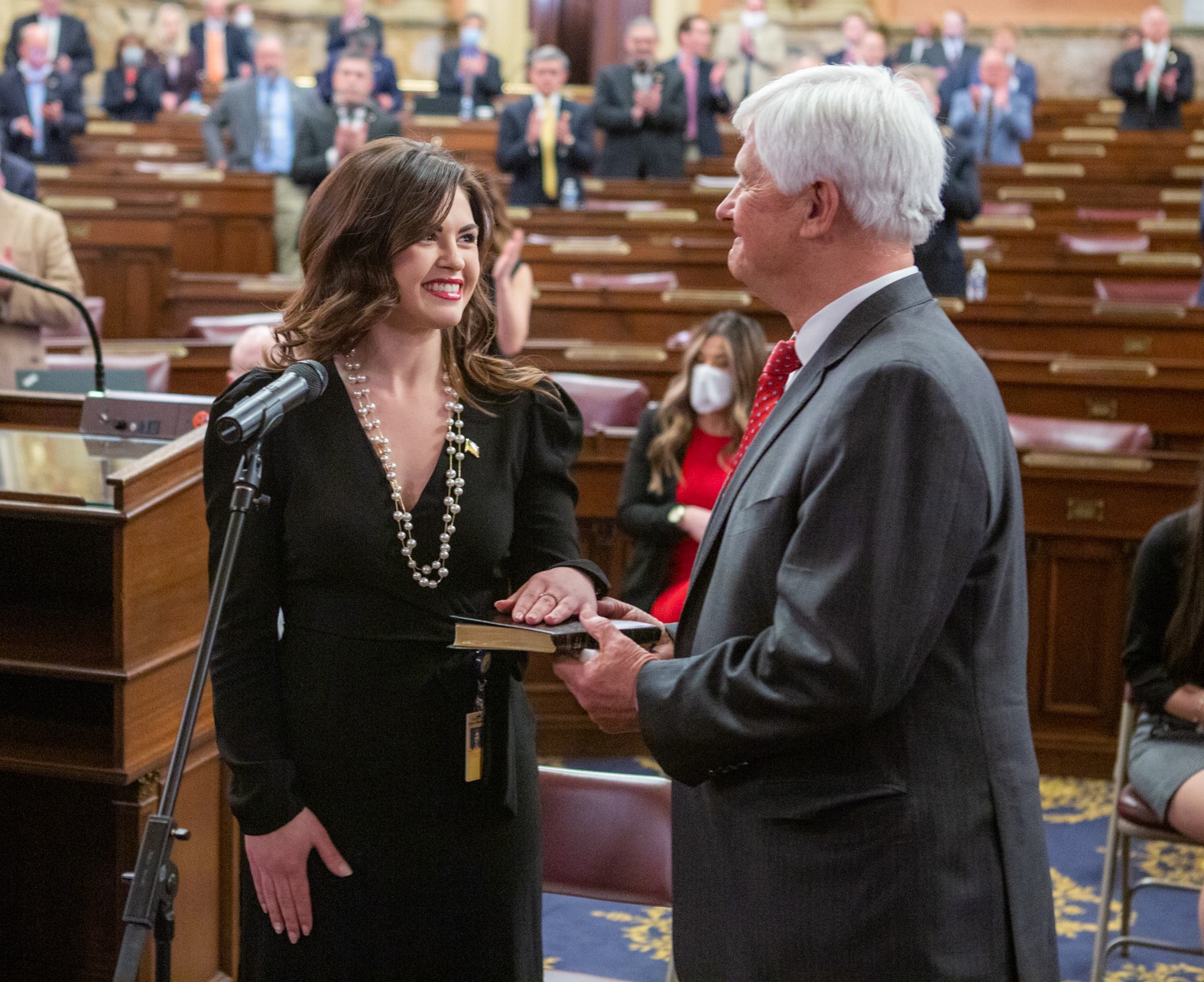 Kathleen “K.C.” Tomlinson takes the oath of office while her father, Sen. Robert “Tommy” Tomlinson, holds the Bible during the ceremony.